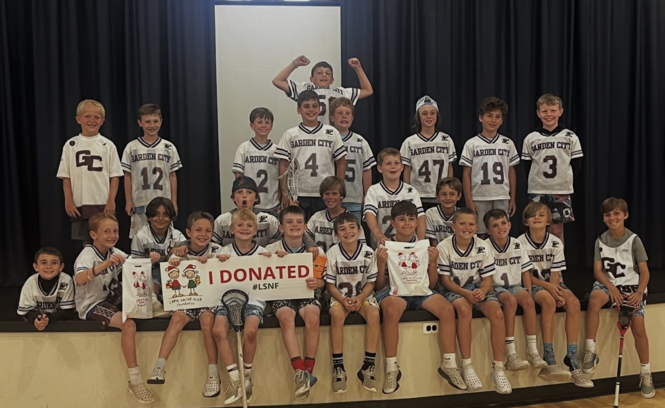 Group of smiling young Garden City athletes in white jerseys posing on a stage, holding an 'I DONATED' banner with #LSNF.